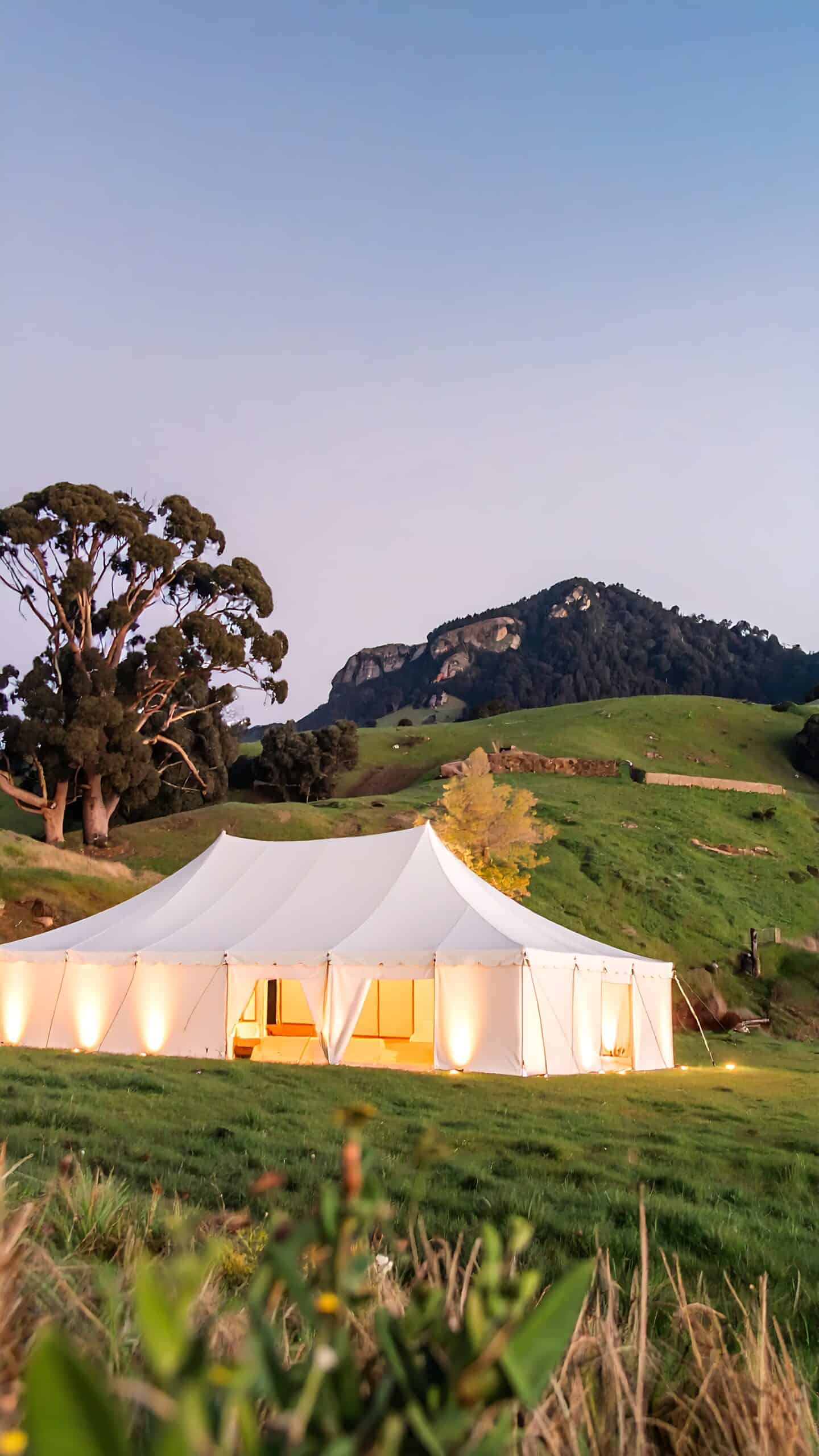 How to Budget for Bar Hire Without Compromising on Style 4 White marquee on grassy hill at dusk