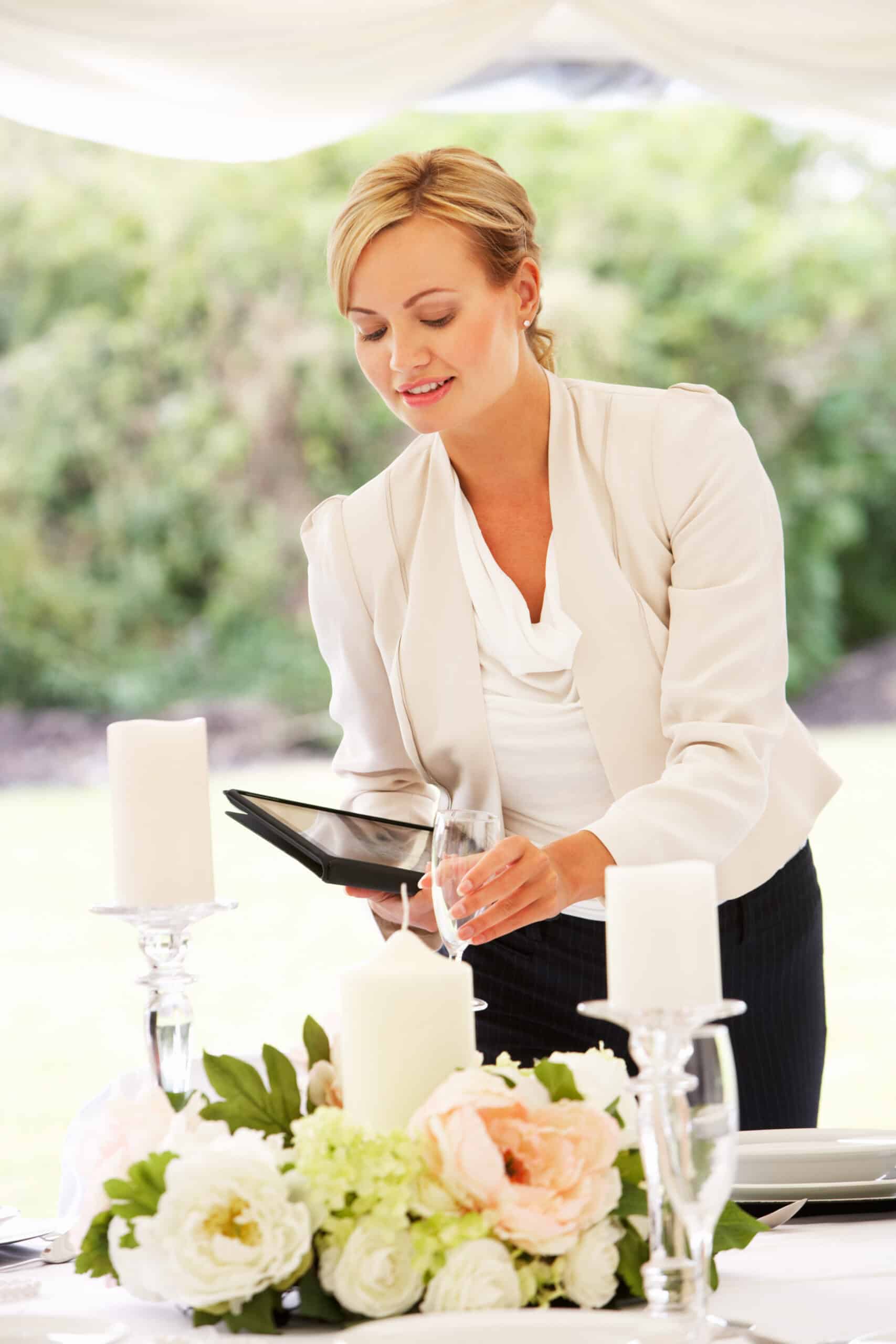 How to Budget for Bar Hire Without Compromising on Style 3 Wedding Planner Checking Table Decorations In Marquee